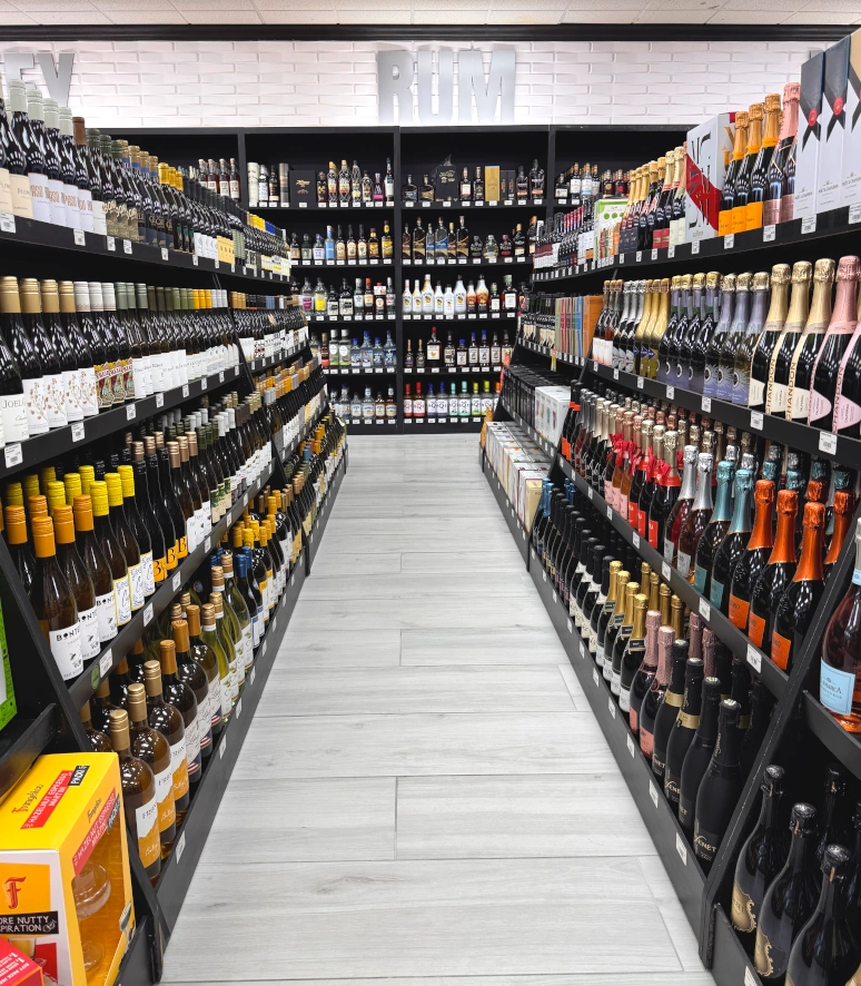 aisle of wine bottles and bottles of liquor along the wall